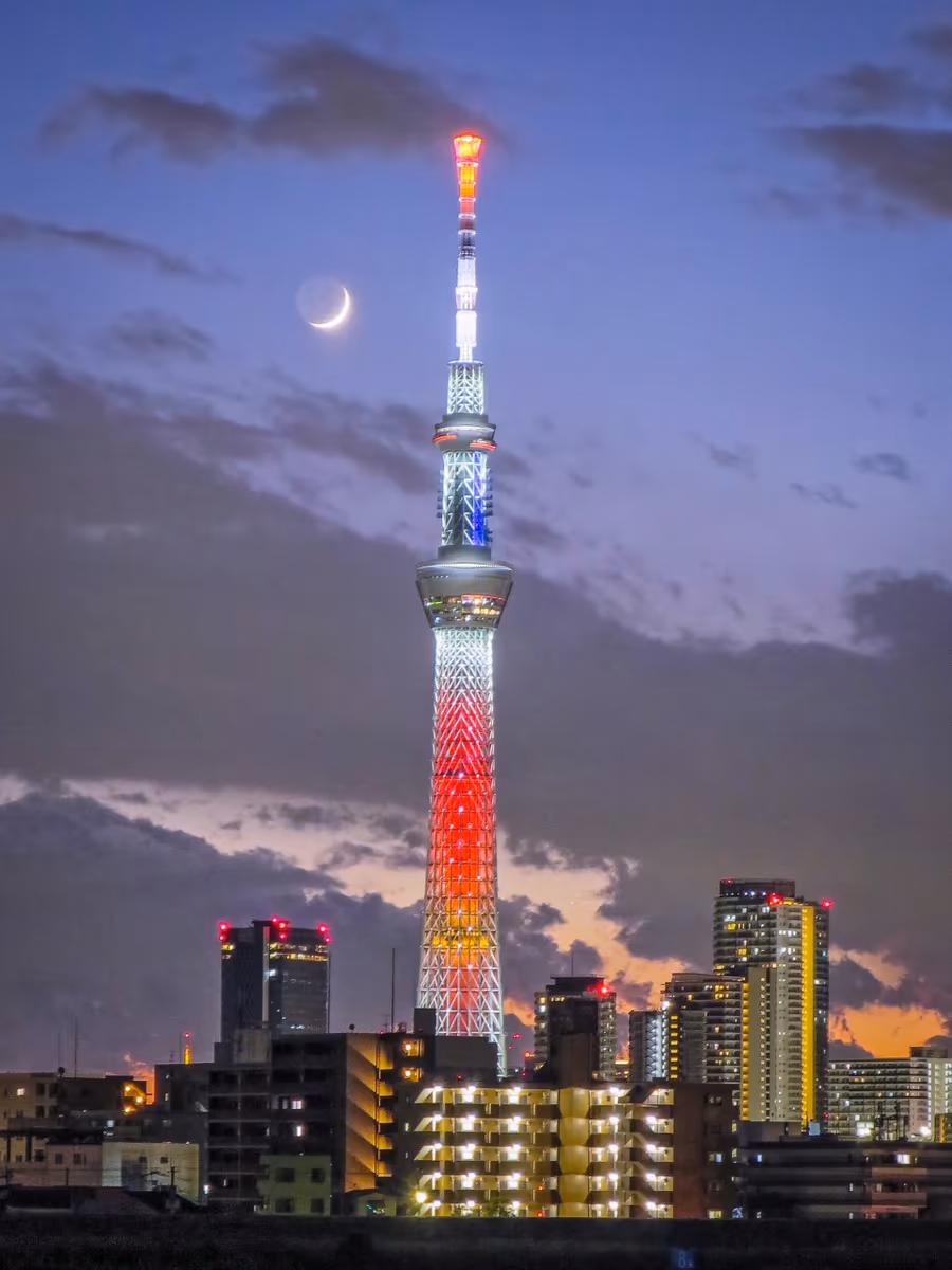 投稿写真：赤いスカイツリーに寄り添う地球照付三日月