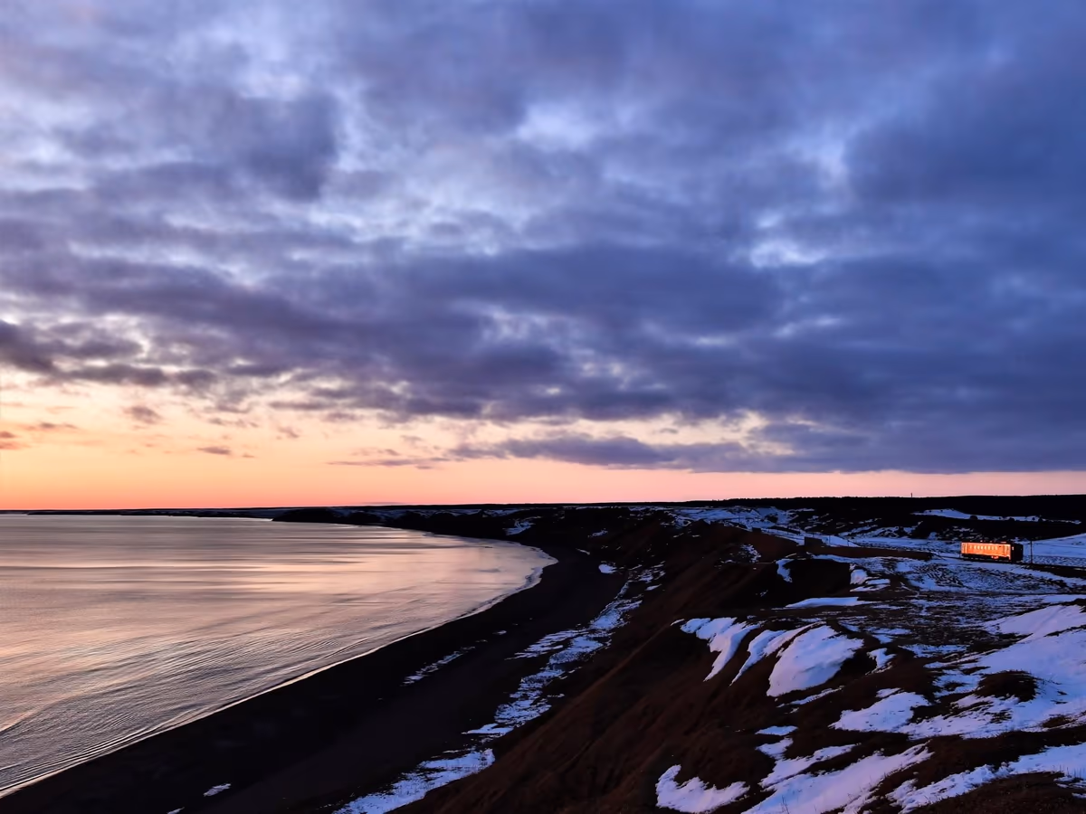 投稿写真：北海道冬の鉄路【夕暮れの空と大地のはざまを走る列車】