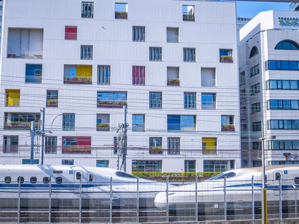 投稿写真：お洒落な建物の前ですれ違う白い新幹線