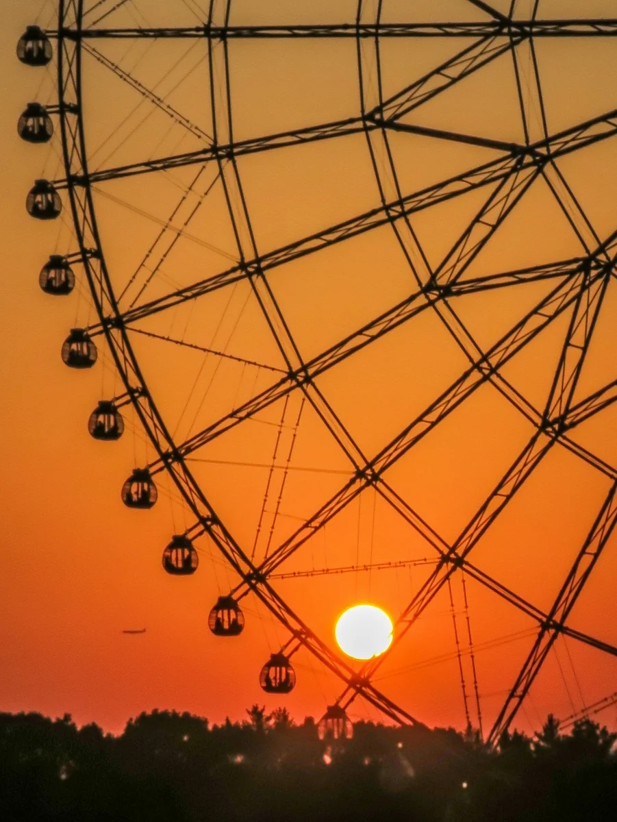 投稿写真：大観覧車の中の夕日と航空機