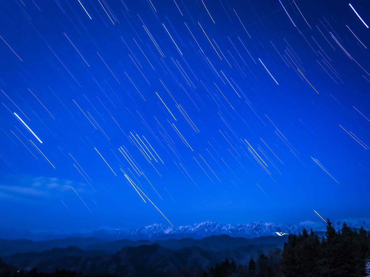 投稿写真：月に照らされた残雪の北アルプスに降り注ぐ星々