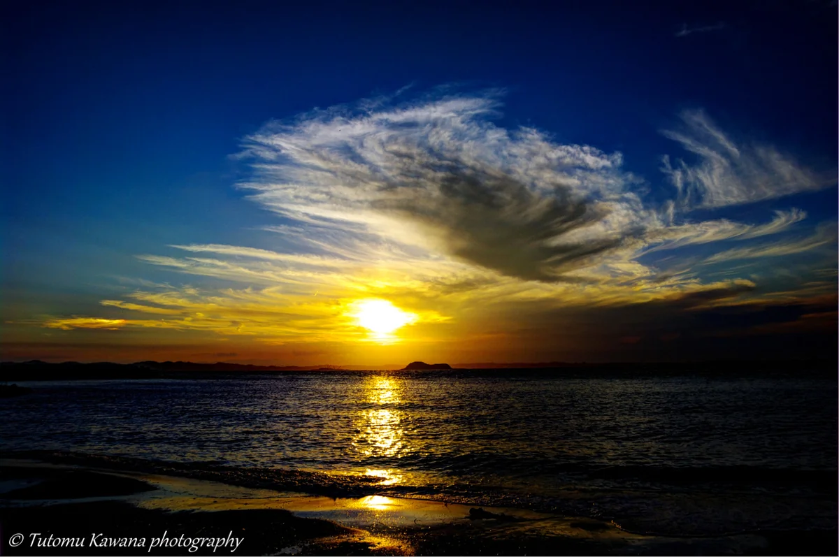 投稿写真：黄昏の渚に拡がりし、晩夏の雲は夕陽の岬を見降ろすかな。