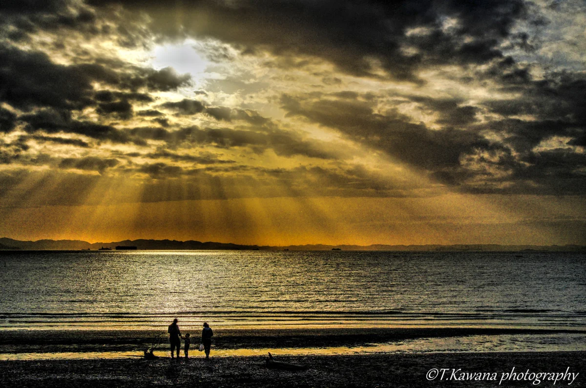 投稿写真：天使の梯子降り注ぐ渚に現れた、家族の姿。