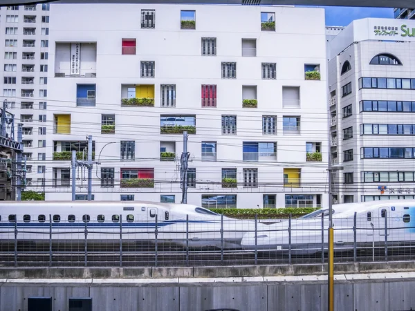 投稿：お洒落な建物の前ですれ違う白い新幹線
