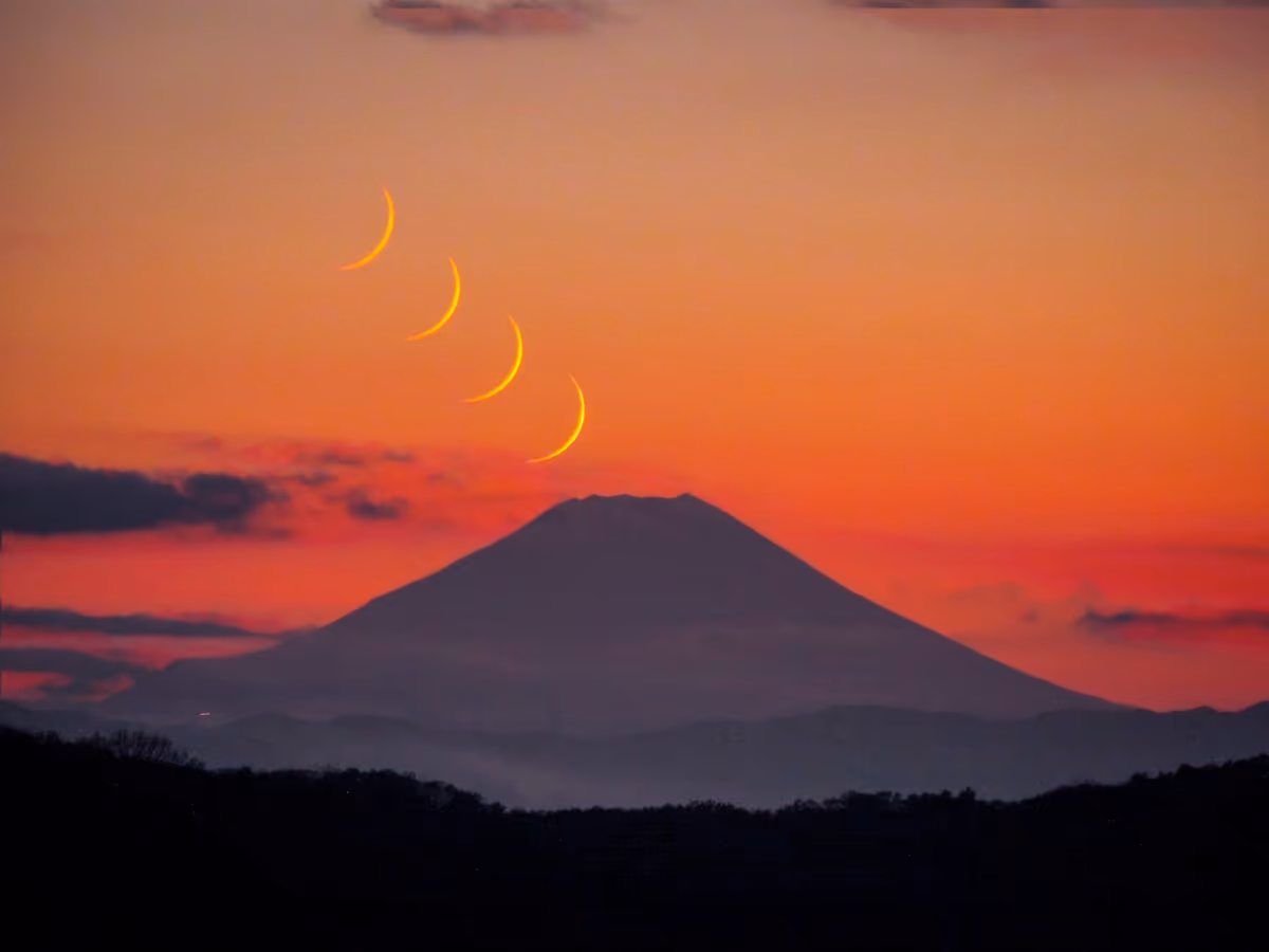 投稿写真：夕焼け空を背景に富士山に沈みゆく三日月