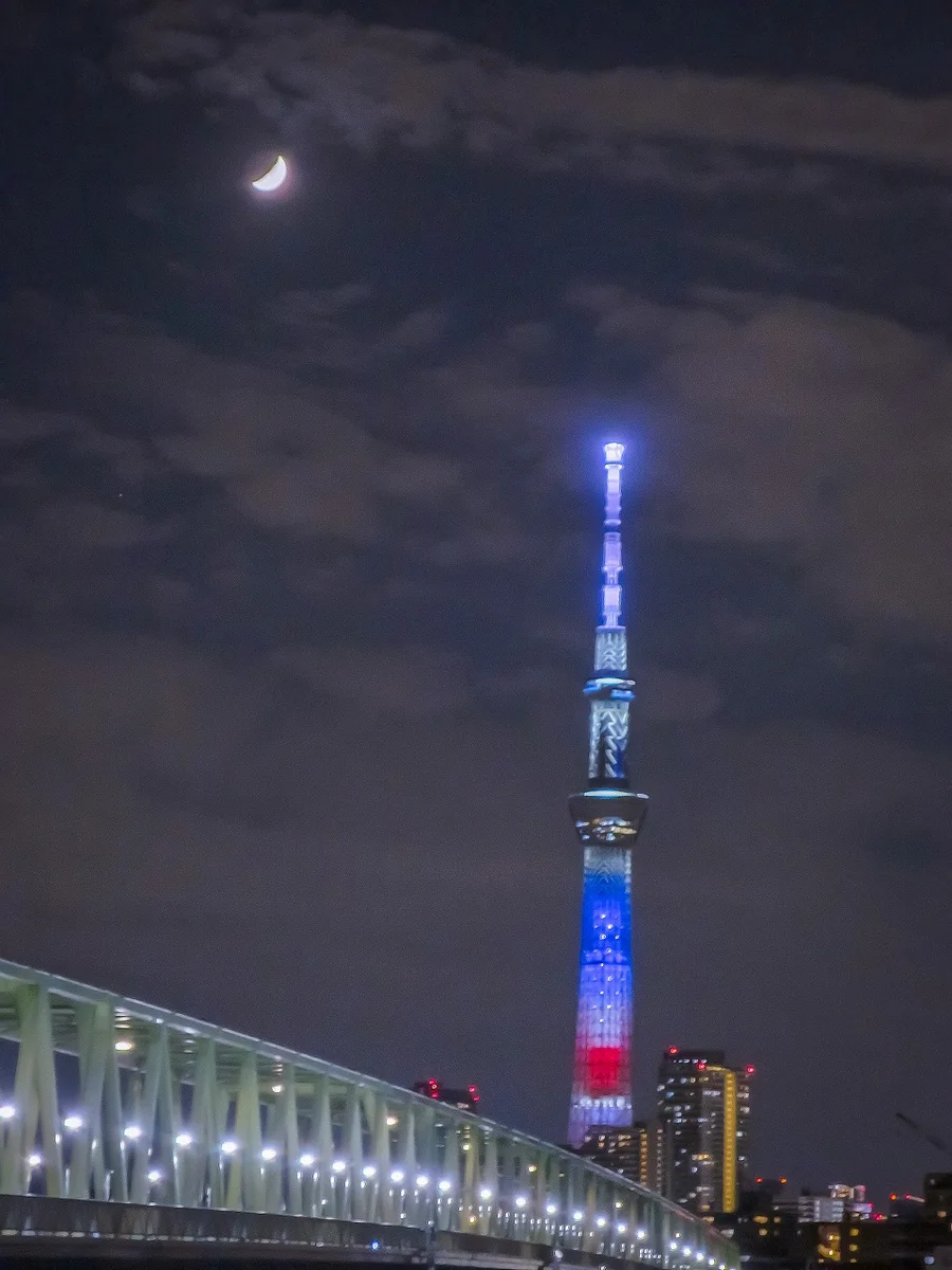 投稿写真：雲間の八日月と星条旗イメージのスカイツリー